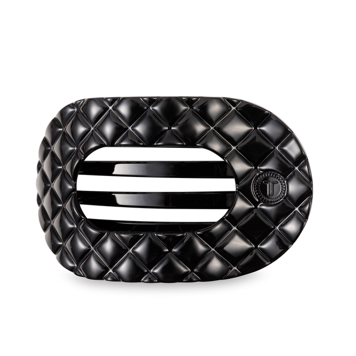 Black oval TELETIES Flat Round Hair Clip with quilted pattern, slats, "T" emblem; available in large and small sizes.