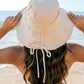 Tie-back Bucket Sunhat: Wide-brim sunhat with adjustable back tie. Sizes available: S, M, L.
