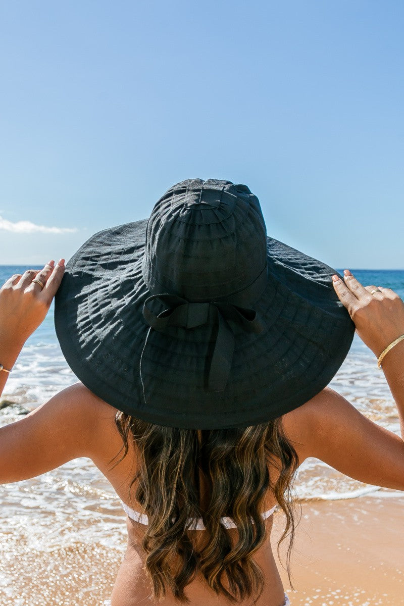 Classic Bow Accent Sunhat: Wide-brimmed sunhat with a classic bow accent, provides UV protection. Sizes available: S, M, L. Color: White.