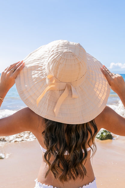 Classic Bow Accent Sunhat: Lightweight sunhat with a wide brim, elegant bow detail, and adjustable fit. Sizes available: S, M, L.