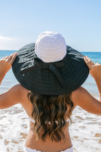 Classic Bow Accent Sunhat: Wide-brimmed sunhat in natural straw with a white bow accent. Provides UPF 50+ sun protection. Adjustable inner band for a secure fit. Sizes available: S, M, L.