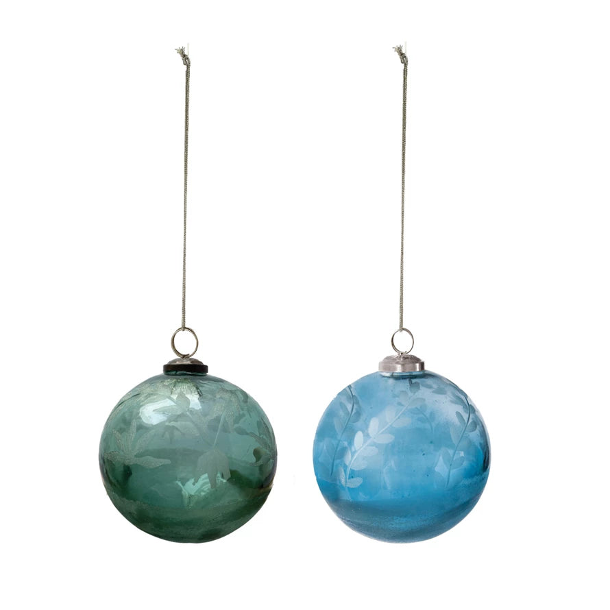 Two green and blue recycled glass ball ornaments with etched leaves and silver hanging loops with twine.