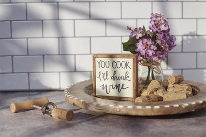 The Mini "You Cook I'll Drink Wine" Box Sign is a decorative piece expressing lighthearted wine appreciation. Size: Approximately 3" x 4".