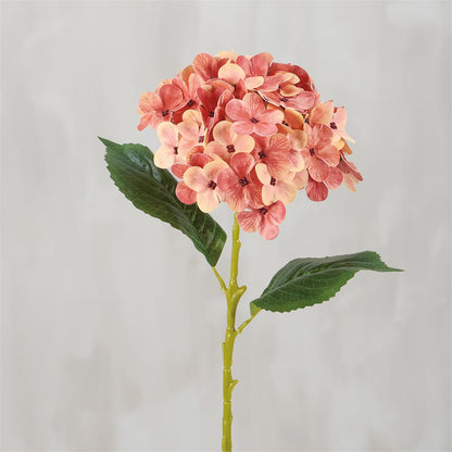 The Pink Hydrangea Floral Pick is an artificial stem with orange and pink hydrangea flowers and two large green leaves. Available size: one standard stem size.
