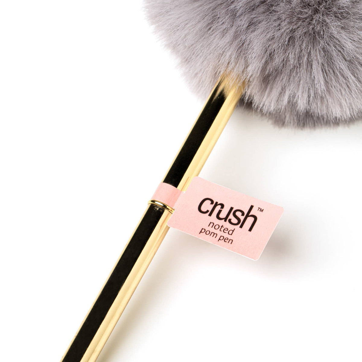 Goldtone barrel pen with large gray plush pom on top and pink tag reading “Crush noted pom pen.” Size options not specified.