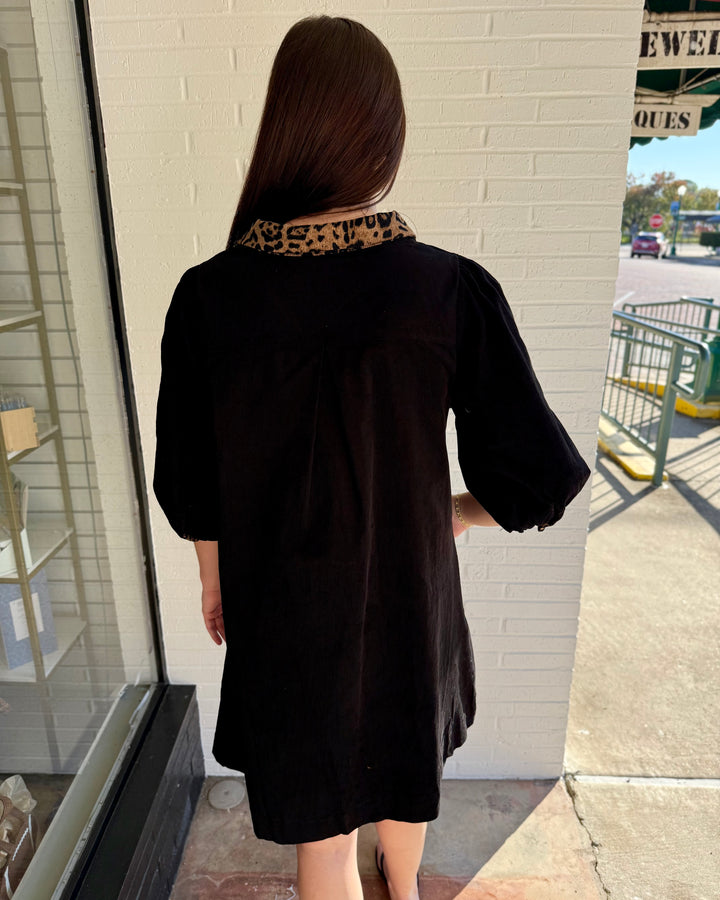 Black shift dress with V-neck, three-quarter sleeves, and leopard-print trim collar.
