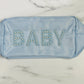 The Baby Pearl Varsity Letter Pouch is a light blue rectangular nylon bag with "BABY" embroidered in large letters on the front, adorned with small pearl-like beads. It features gold zippers on both ends. Sizes available: Small, Medium, Large.