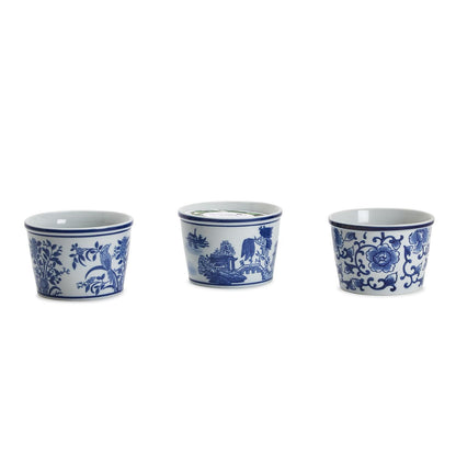 Three blue and white ceramic cups with floral and landscape designs on a white background