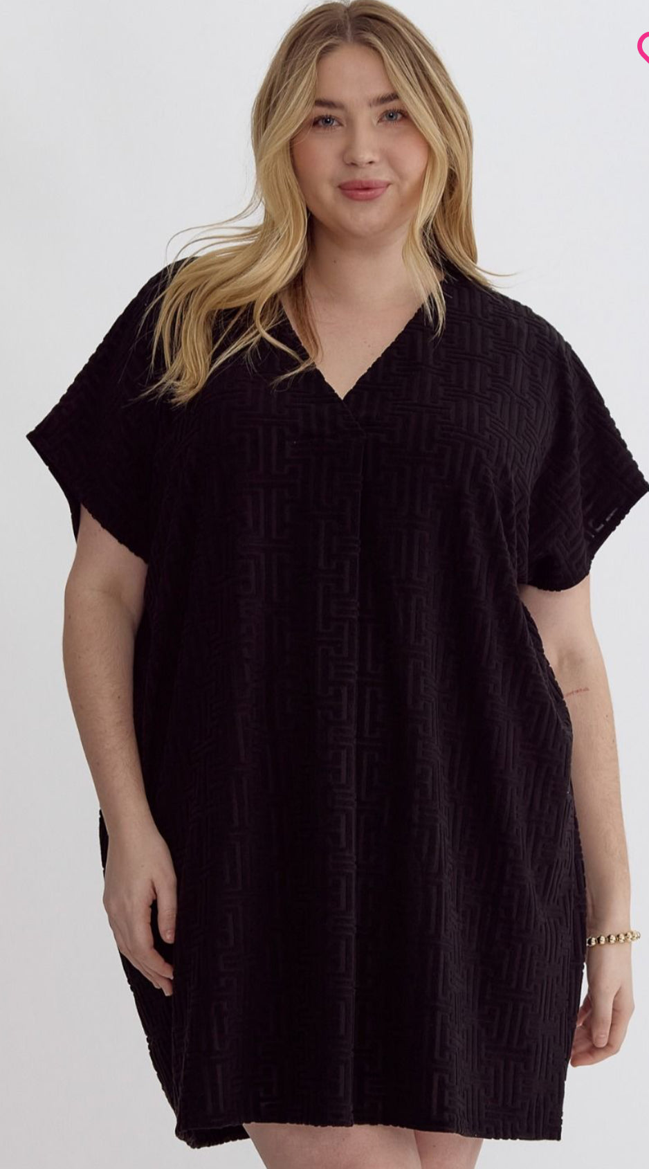 The Black Textured Terry Dress is available in sizes small, medium, and large. It features short sleeves.