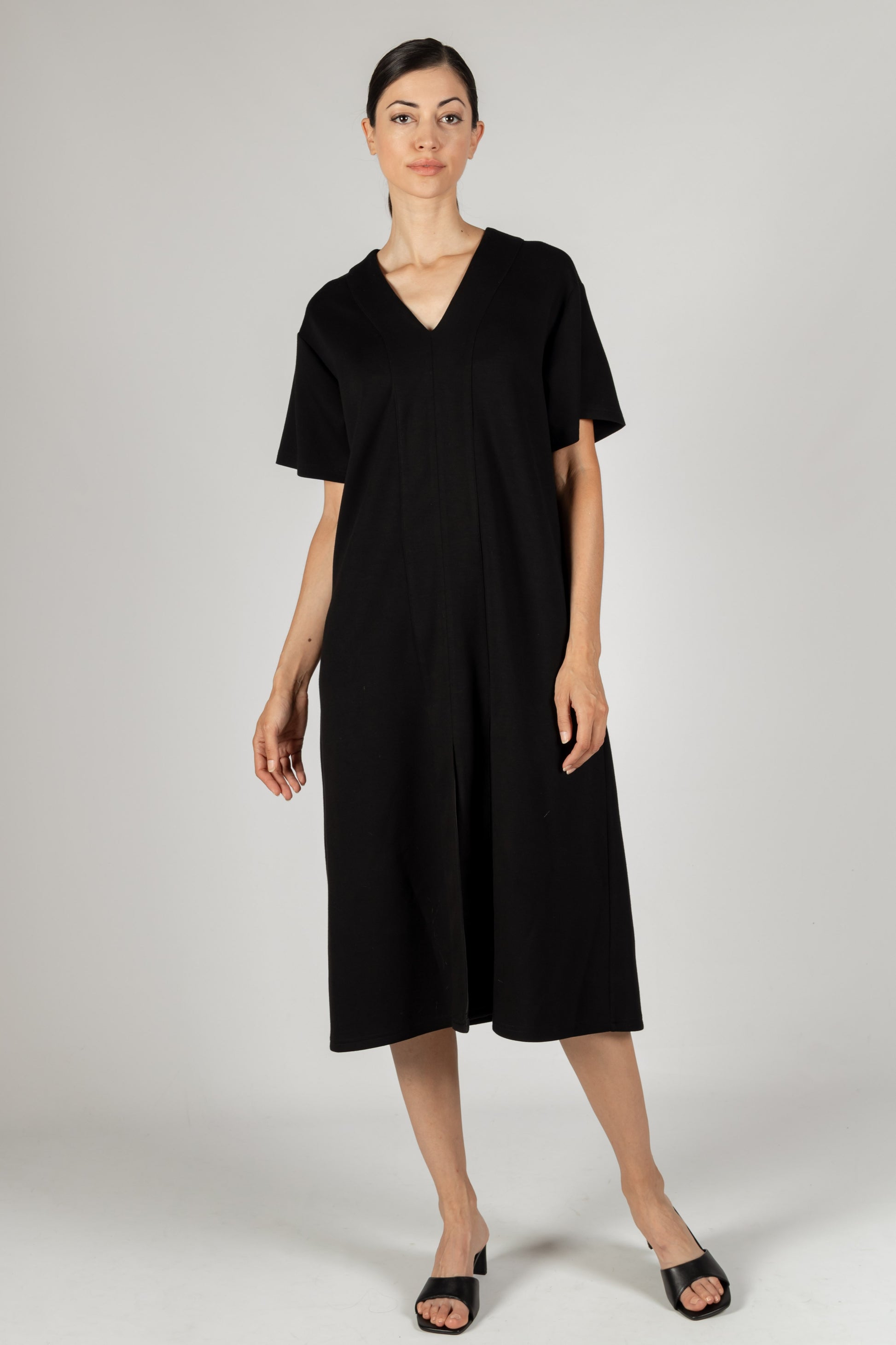 The P. CILL Butter Modal V Neck Midi Dress is a fashionable black dress features short sleeves and midi-length culotte-style pants. It is available in various sizes.