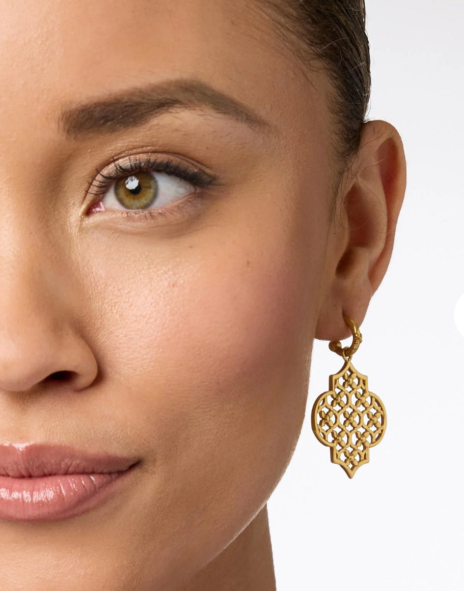 The Helene Statement Hoop & Charm Earring is a standout piece made of 24K gold plate. The earring prominently features a hoop design adorned with an elegant charm. It is available in one standard size.