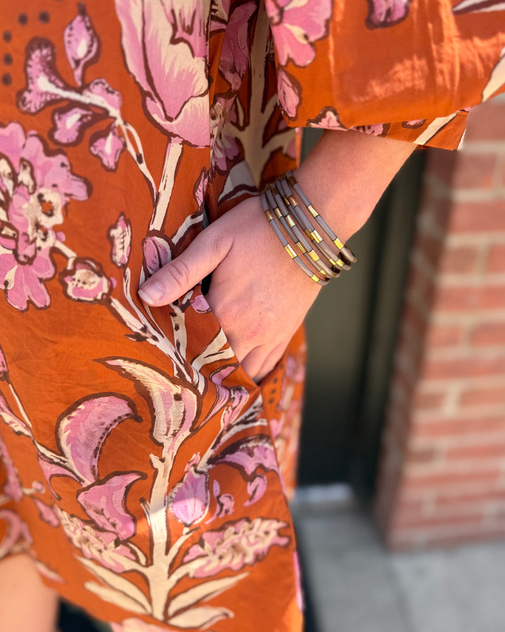 Autumn Rust Long-sleeve Dress with pink floral patterns and pockets. Available in sizes XS–XL.