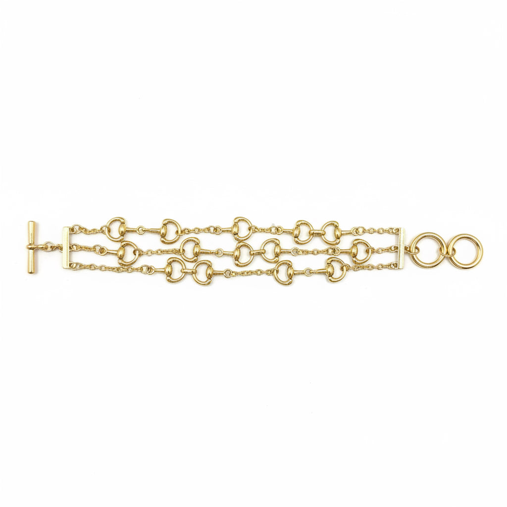 Mark Multi Strand Horse Bit Toggle Bracelet in gold with three layered strands and interlocking circular and oval links, featuring a left-side toggle clasp. Available sizes: S, M, L.