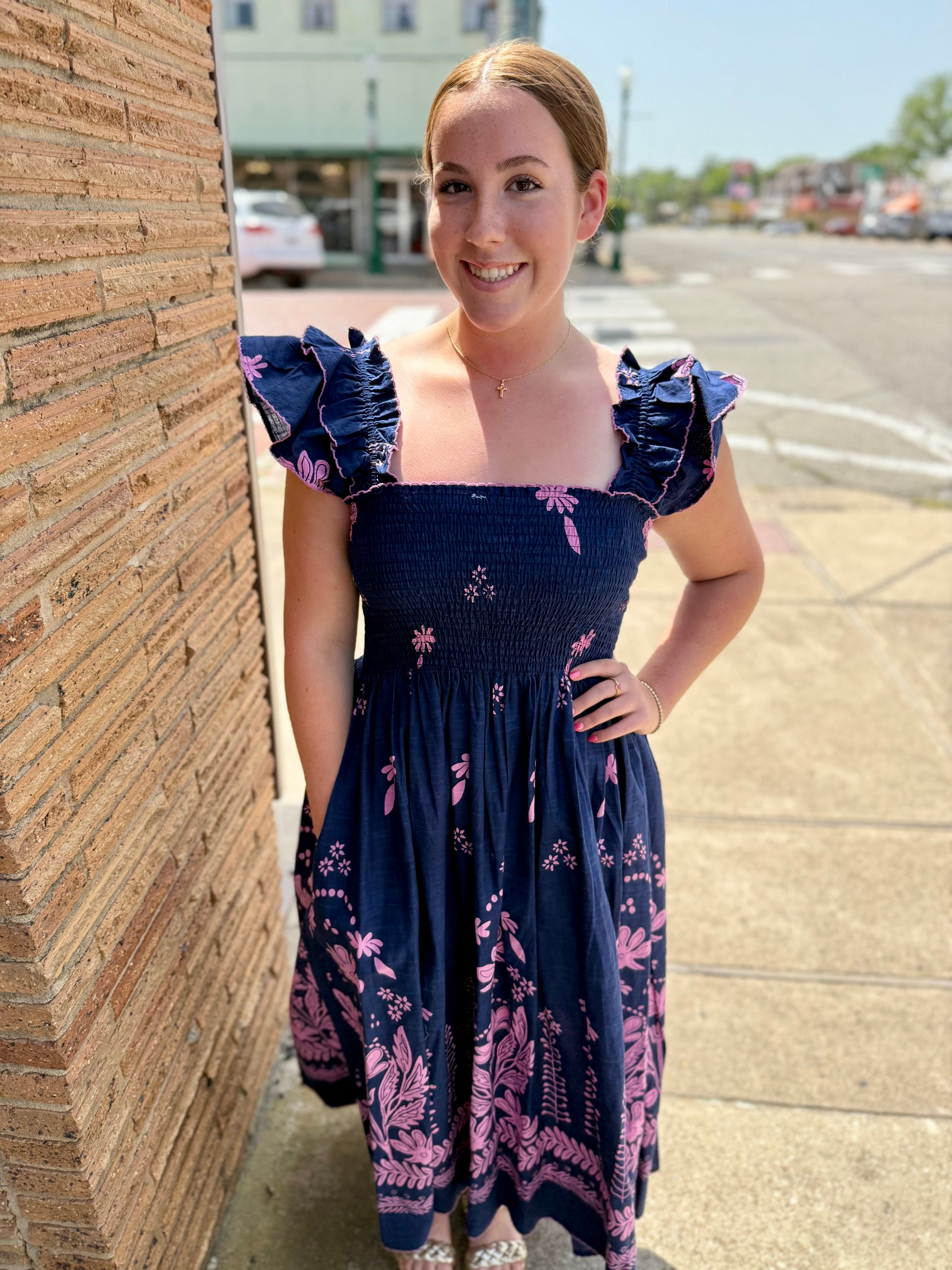 Navy Smocked Border Dress: cotton, pink floral pattern, ruffled sleeves. Available in XS–XL.
