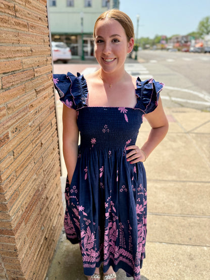 Navy Smocked Border Dress: cotton, pink floral pattern, ruffled sleeves. Available in XS–XL.