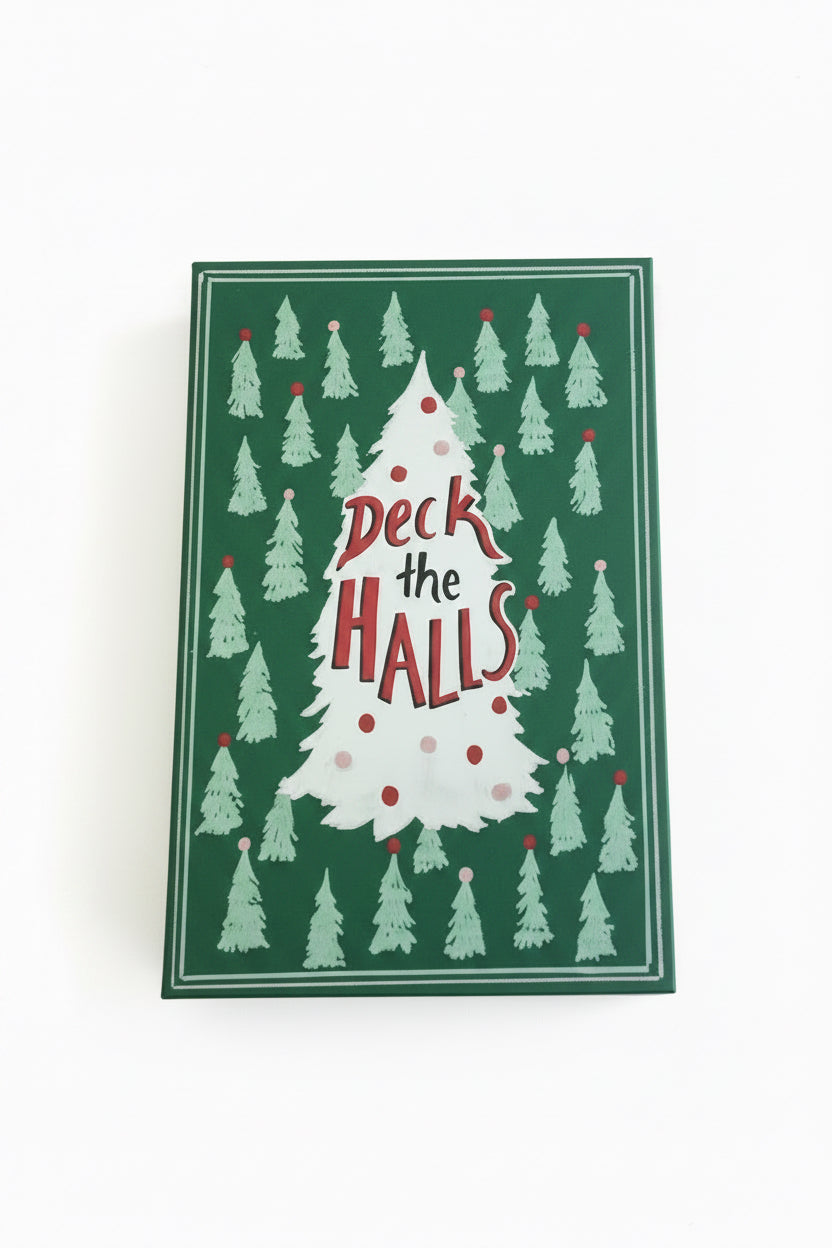 Dark green rectangular canvas book storage box with light green Christmas trees and a central white tree reading “Deck the Halls.”.
