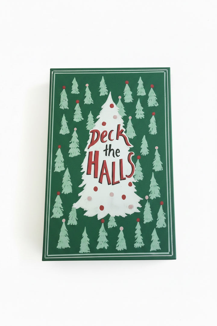 Dark green rectangular canvas book storage box with light green Christmas trees and a central white tree reading “Deck the Halls.”.