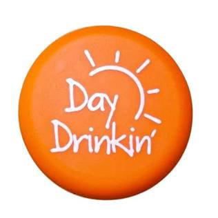 Orange circular Wine Cap with sun graphic and “Day Drinkin’” in white script. Available in standard wine bottle size.