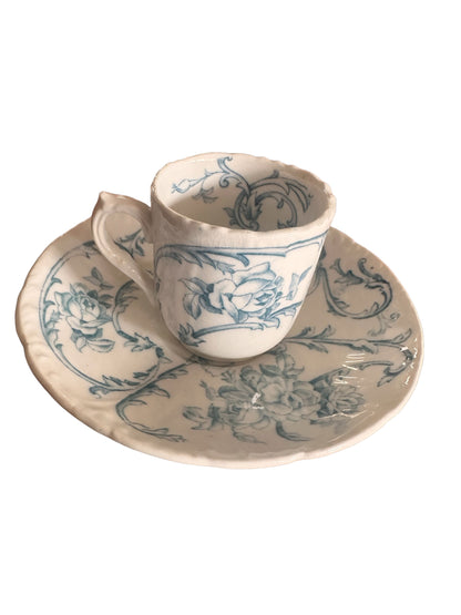 Antique hand-painted porcelain demitasse cup and saucer set, white with blue floral patterns, gently irregular edges. Sizes vary.