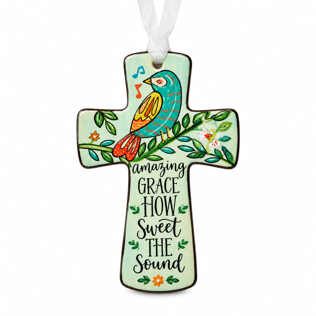 Cross-shaped Christian bird ornament featuring a bird on a branch, the text “Amazing Grace How Sweet The Sound,” and a white ribbon.