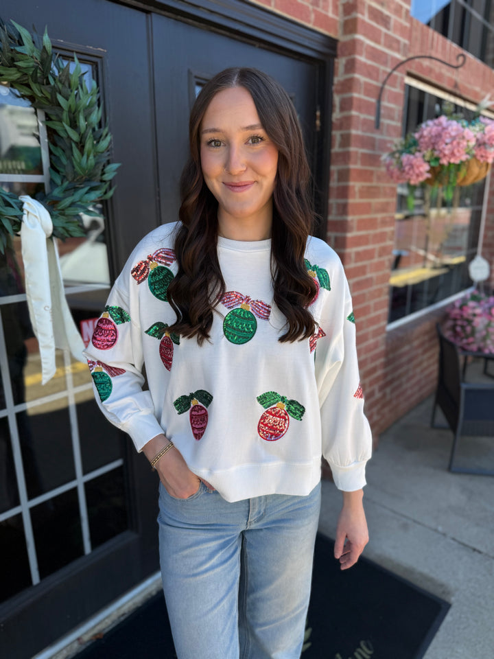 Cream Millie Baubles &amp; Bows Sweatshirt with colorful, sequined Christmas baubles and red bows. Available in multiple sizes.