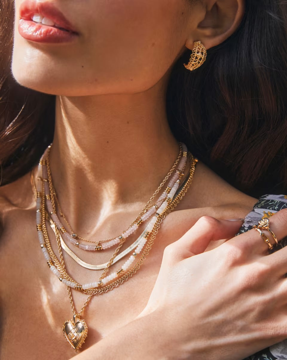 Krista Lace Gold Huggie Earrings by Kendra Scott, available in small and medium sizes.