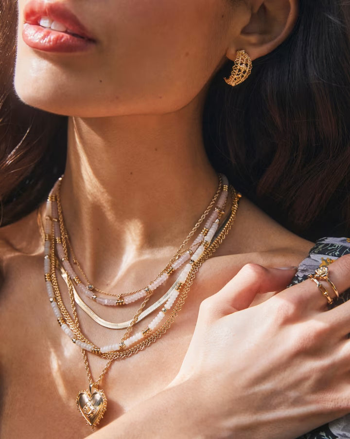 Krista Lace Gold Huggie Earrings by Kendra Scott, available in small and medium sizes.