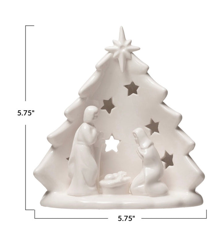 White ceramic nativity tree candle holder with scene cutout and star openings, 5.75 inches tall and wide.