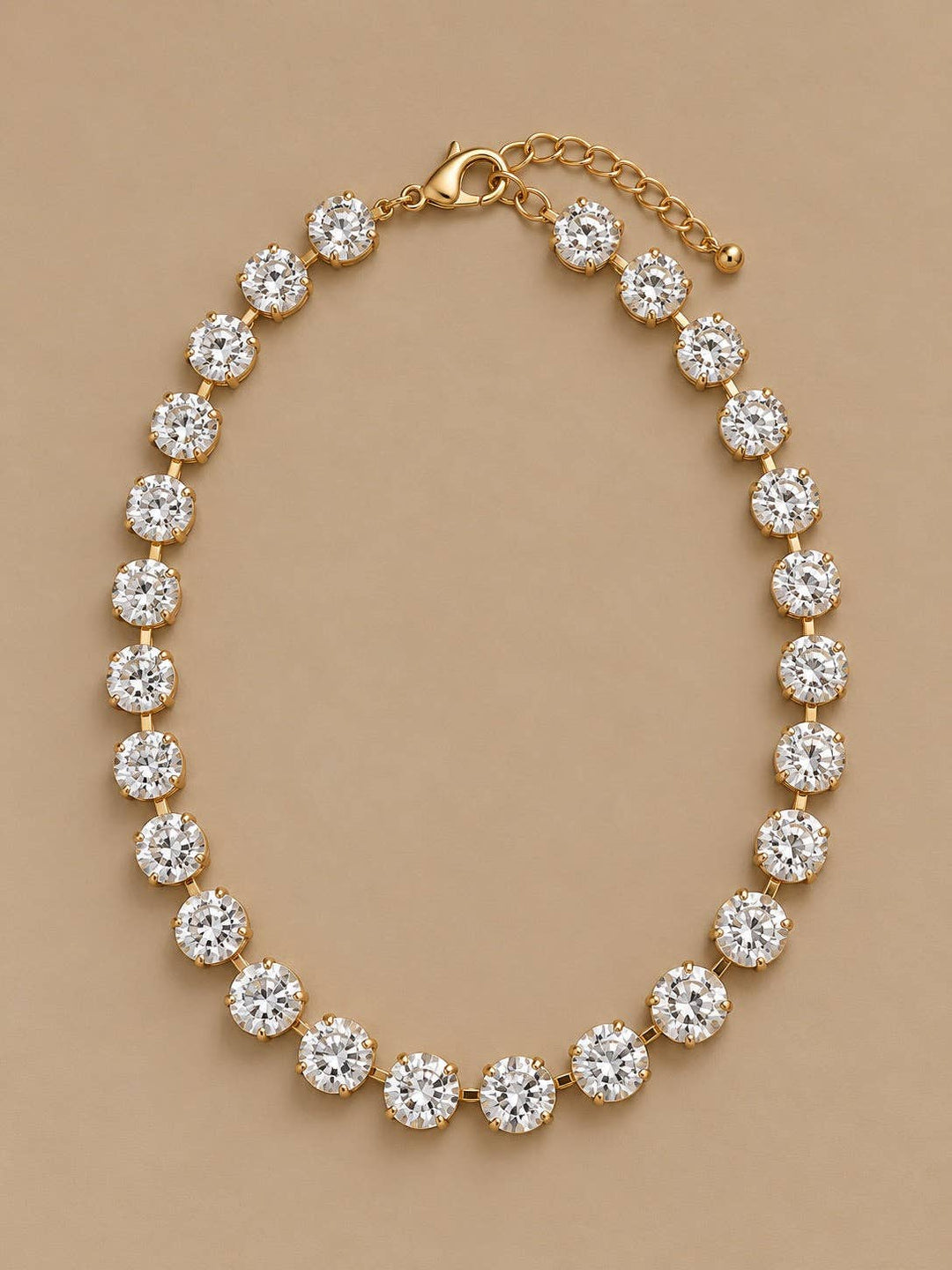Gold-tone Gemmies round clear faceted stone necklace with lobster claw clasp and extender chain.
