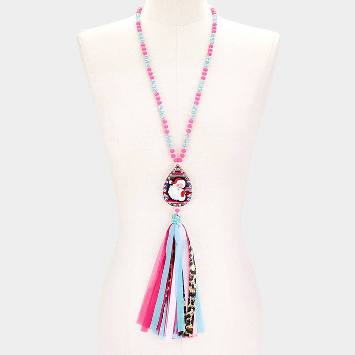 Santa Claus serape teardrop tassel long necklace with pink beads, Santa pendant, and multi-colored fabric tassel.