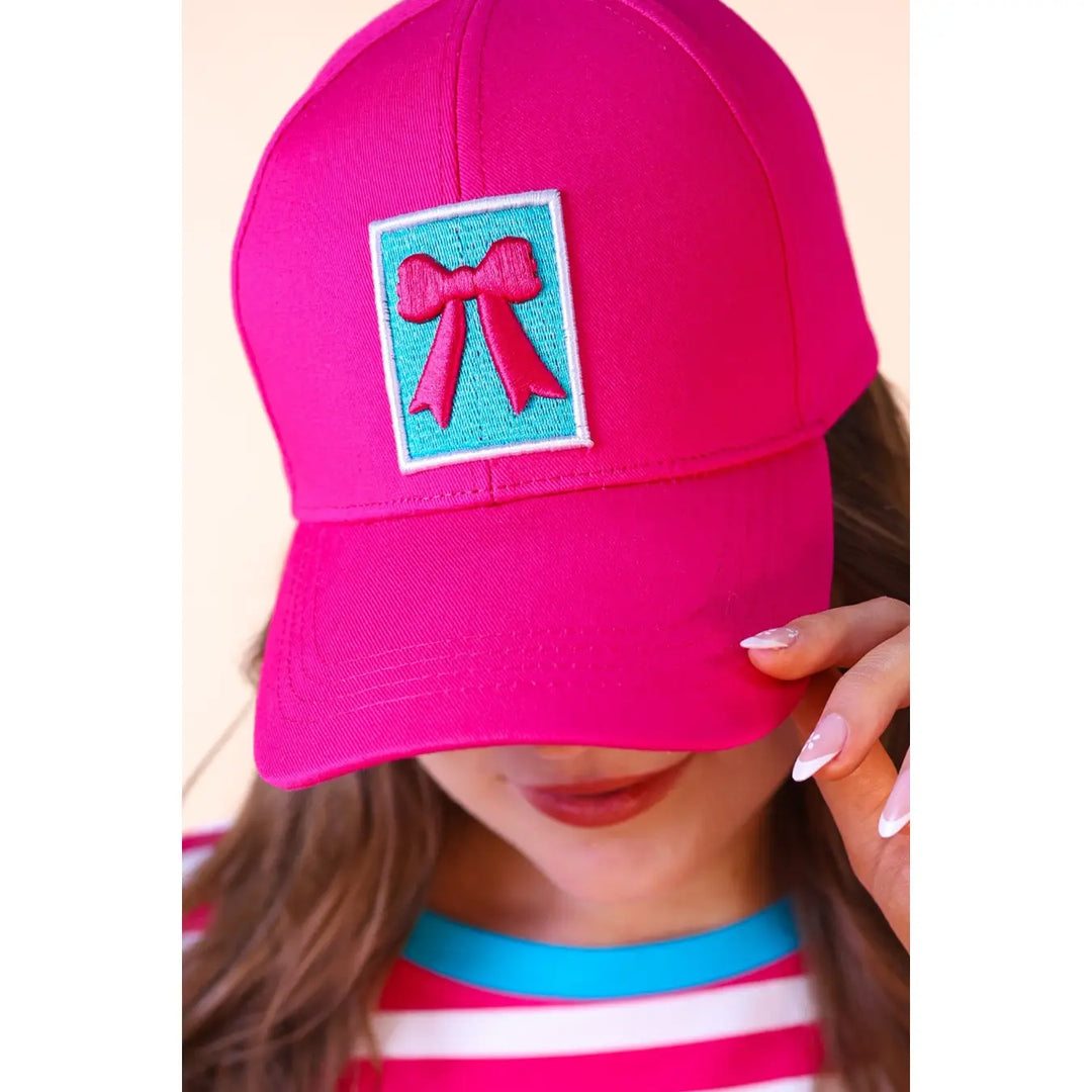 Gianna Bow Hat | Pink: bright pink cap, embroidered red bow on blue. Available sizes: S, M, L.