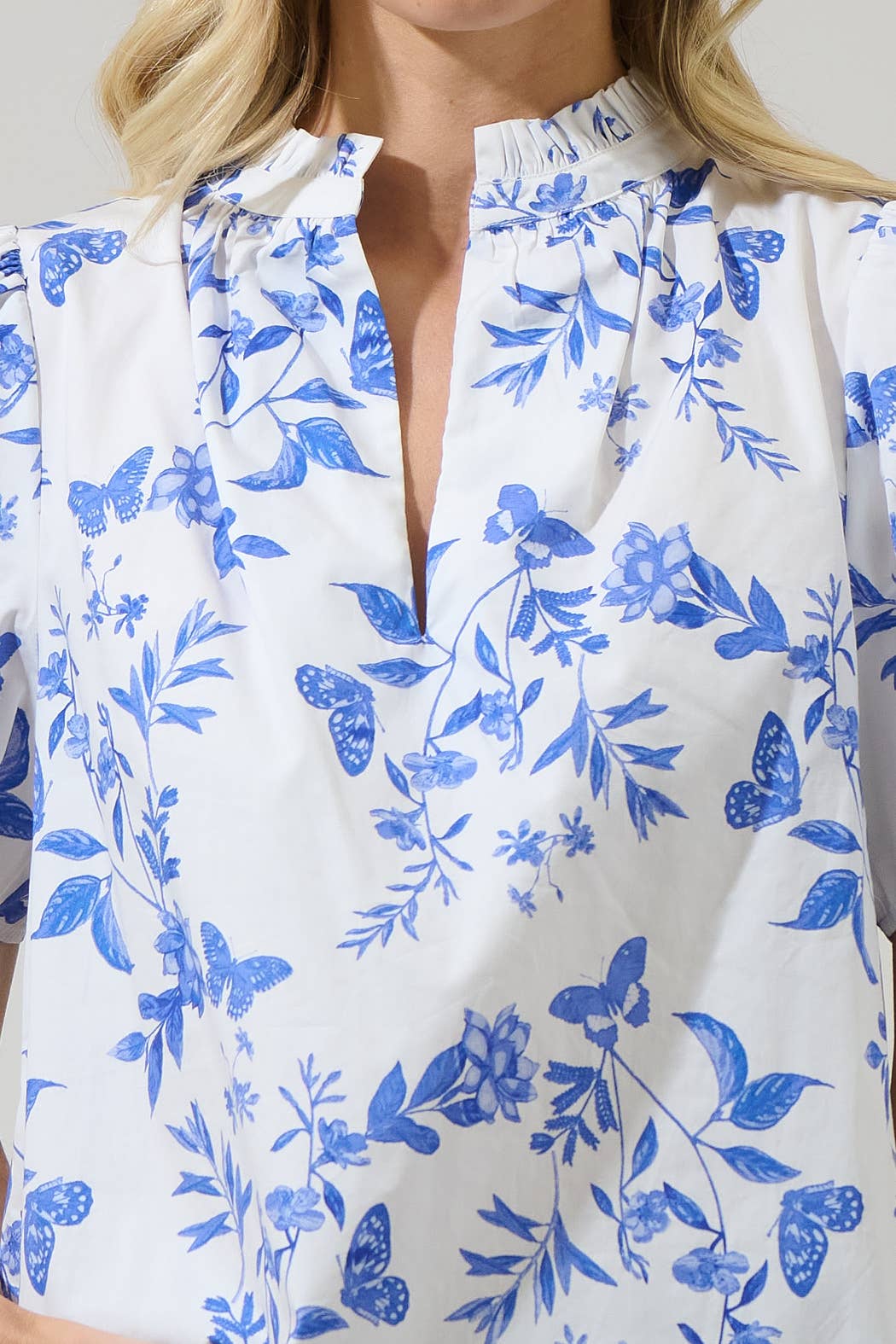 Leya Floral Inaya Split Neck Top: blue/white, butterfly/floral print, ruffled collar, split neck. Sizes XS-XL.
