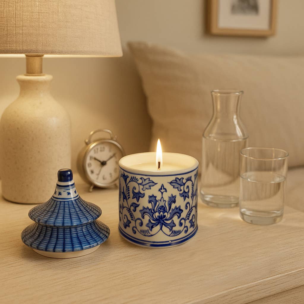 Blue Ceramic Plumeria Chinoiserie Pagoda Candle, 9 oz, in a blue and white jar with lid; candle is lit.