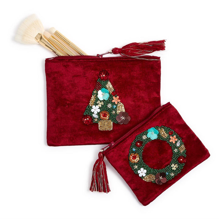 Two dark red velvet holiday pouches with tassels, one featuring a beaded Christmas tree and the other a beaded holiday wreath.