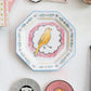 Octagon-shaped ceramic plate with a painted yellow bird in center, pink and blue patterns. Available sizes: 8", 10", 12".