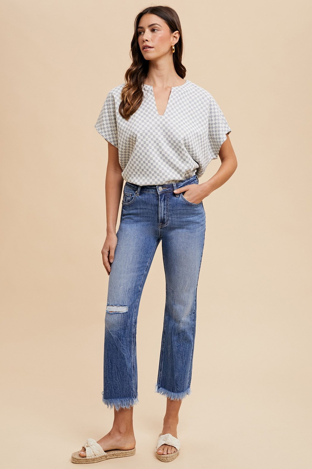 White, short-sleeved checkered blouse. Comfort Stretch Straight Leg Frayed Hem Jeans in blue. Sizes: 24, 25, 26, 27, 28.