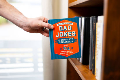 World’s Greatest Dad Jokes: The Complete Collection" book with blue and orange cover, 350+ jokes. Sizes available.