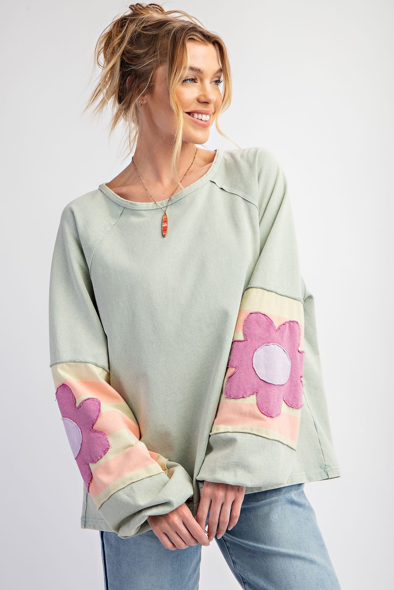 Light green Flower Patch Terry Knit Washed Pullover with pastel pink and purple flower sleeve designs. Sizes: S, M, L.