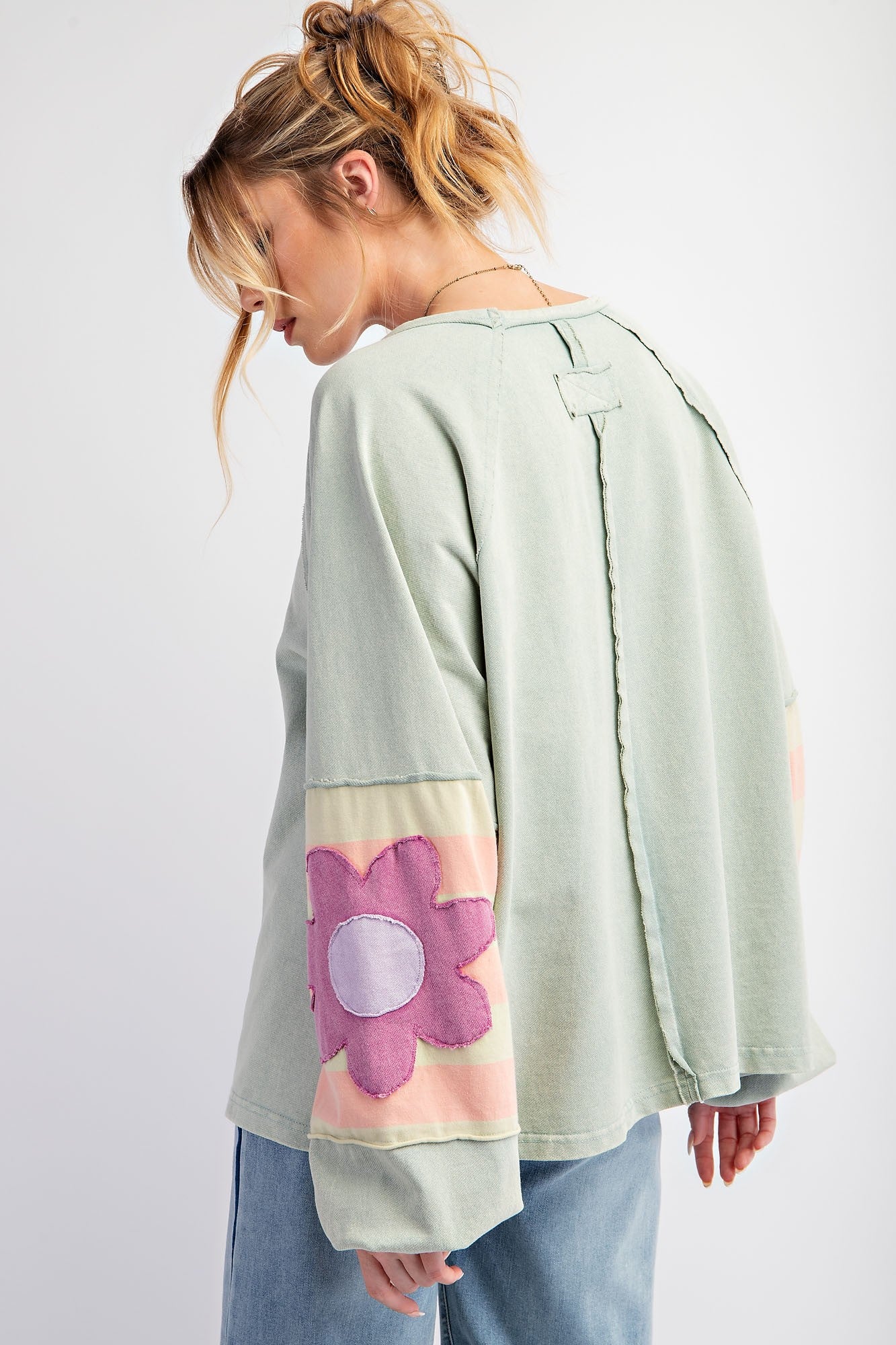 Flower Patch Terry Knit Washed Pullover with large pink flower patches on the sleeves. Available in sizes S, M, L, XL.