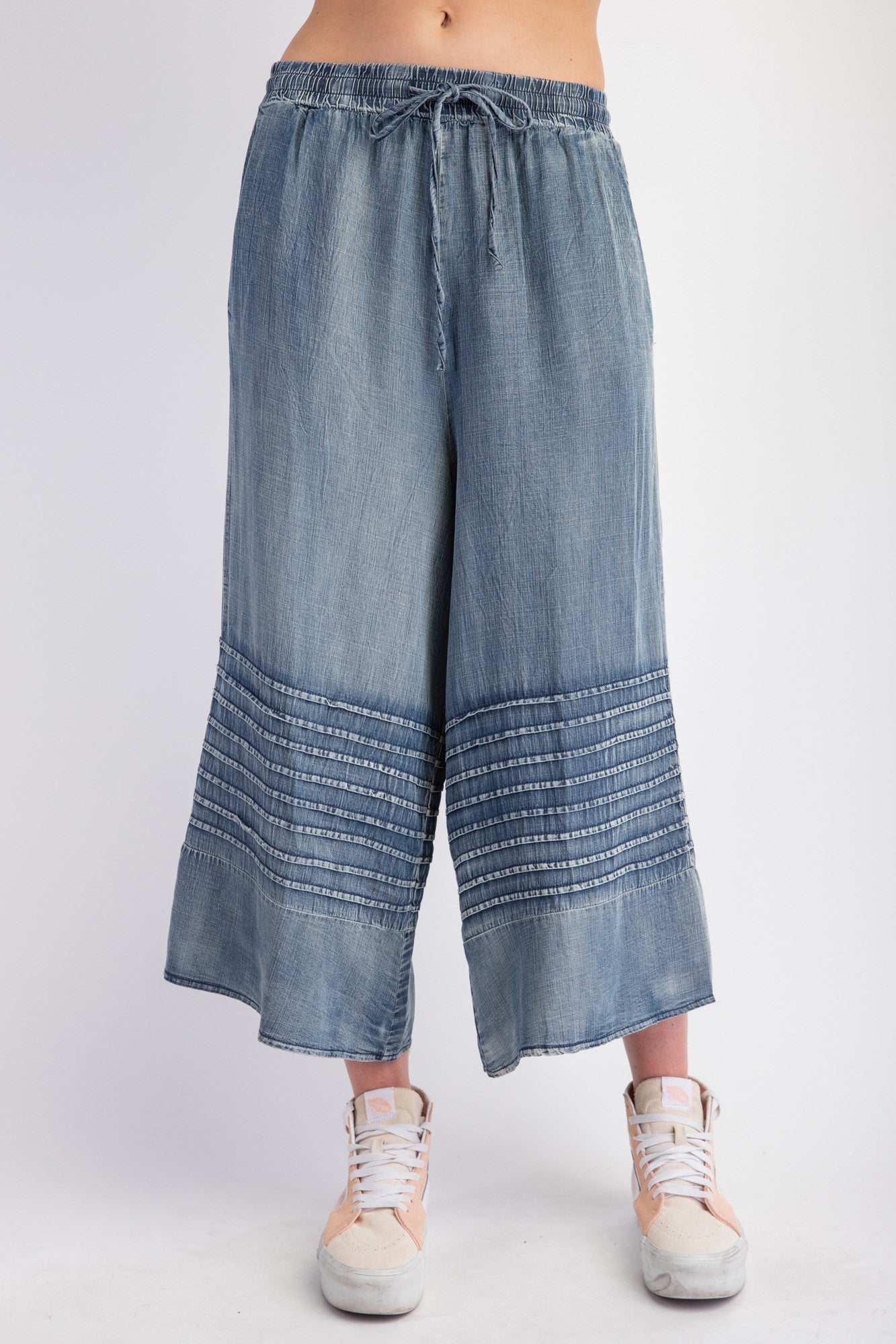 Mineral Washed Chambray Wide Leg Capri Pants. Features: drawstring waist, horizontal stitched details near the bottom, cropped just above the ankles. Sizes available: S, M, L, XL.