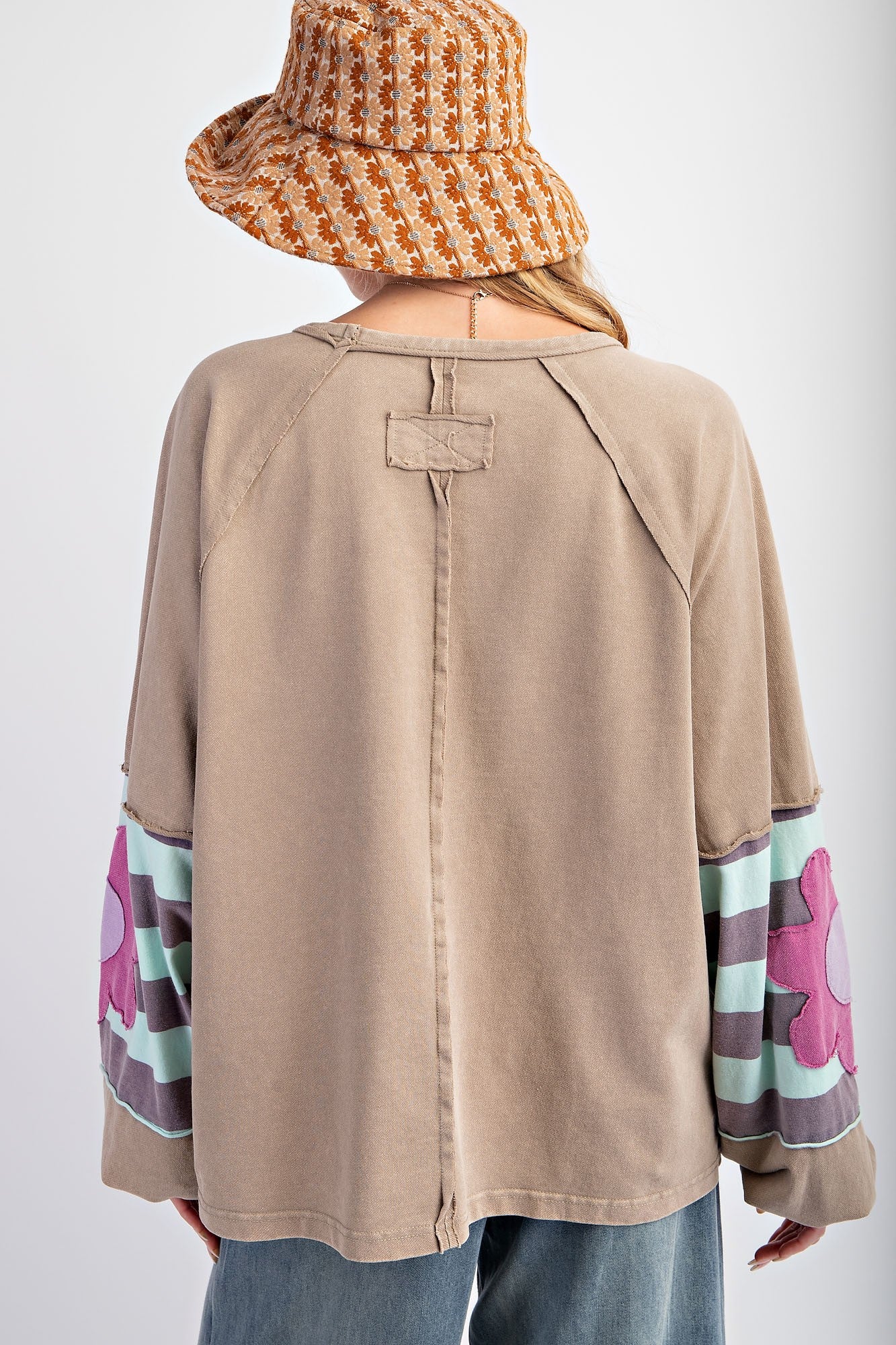 Flower Patch Terry Knit Washed Pullover. Beige long sleeves with purple and white floral patterns, cozy knit texture. Available sizes: S, M, L.