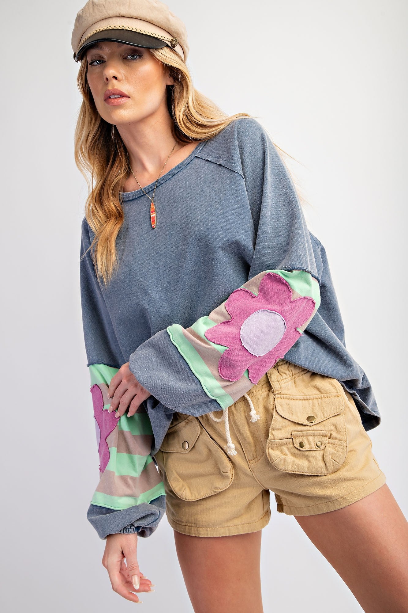 **Flower Patch Terry Knit Washed Pullover:** Cozy pullover with colorful, floral-patterned sleeves. Sizes available: S, M, L, XL.

**Tan Cargo Shorts:** Tan shorts with multiple pockets. Sizes available: S, M, L, XL.