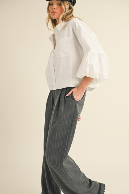 The Button Down Bubble Sleeve Top features bubble sleeves and a button-down front, offering a blend of classic style and modern elegance. Available in sizes XS to XL.