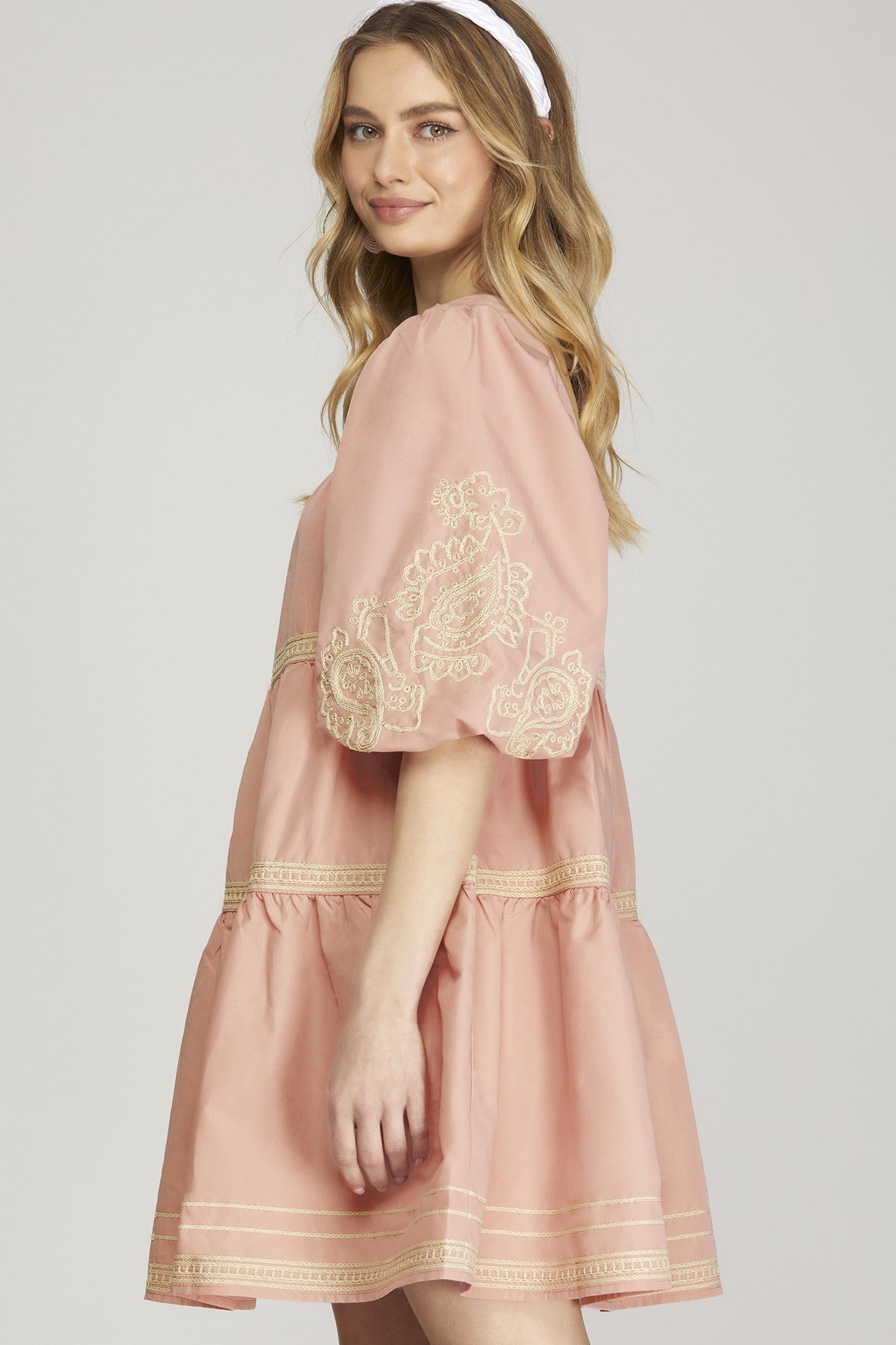 The Blossom Cascade Dress features intricate embroidery and puff sleeves. Available in sizes XS to XL.