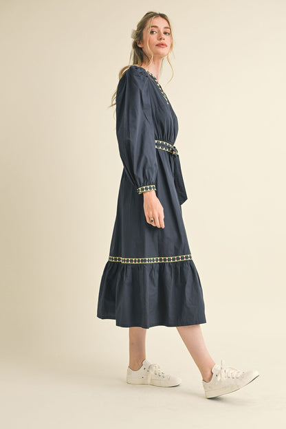 Kathy Embroidered Belt Midi Dress in navy blue with decorative trim, matching belt, and long sleeves. Sizes: XS-XL.