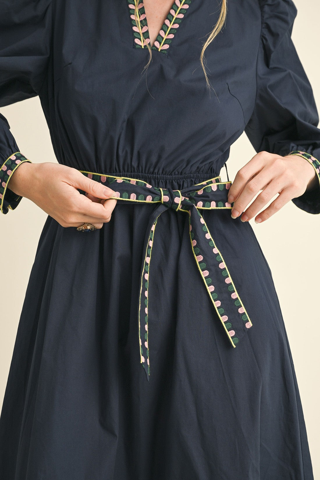 Navy Kathy Embroidered Belt Midi Dress with patterned belt, matching trim on cuffs and neckline. Available in sizes XS-XL.