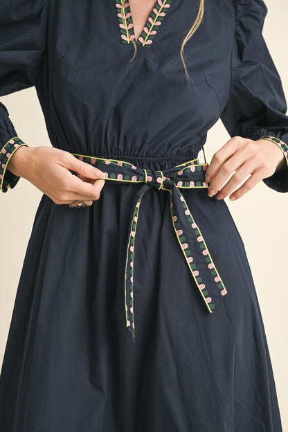 Navy Kathy Embroidered Belt Midi Dress with patterned belt, matching trim on cuffs and neckline. Available in sizes XS-XL.