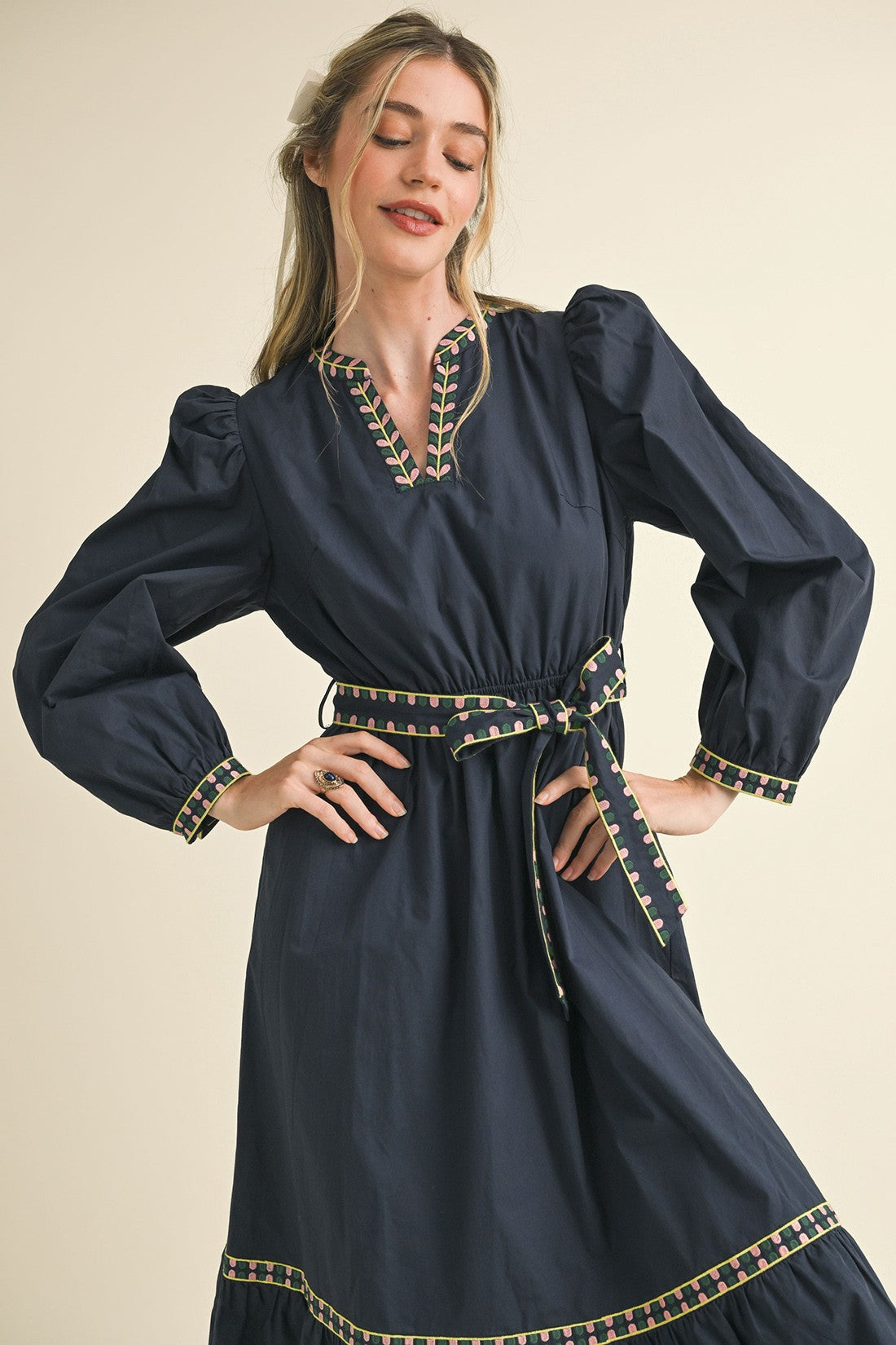 Kathy Embroidered Belt Midi Dress in navy blue with puffed sleeves, delicate trim, waist tie. Available in sizes XS-XL.