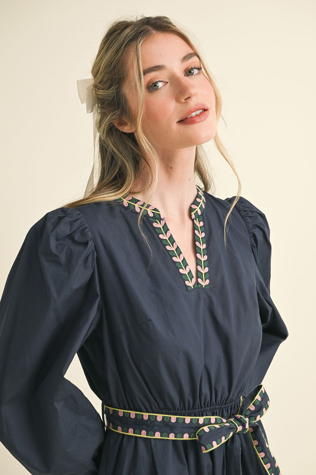 Kathy Embroidered Belt Midi Dress in dark blue with puff sleeves, pink and green leaf details. Available in sizes XS–XL.