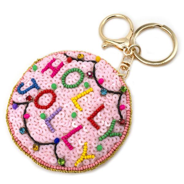 Christmas Spirit Keychains: Round keychain with pink beads and "HOLLA" pattern in vibrant letters. Features a gold ring and clasp. Size: One size fits all.